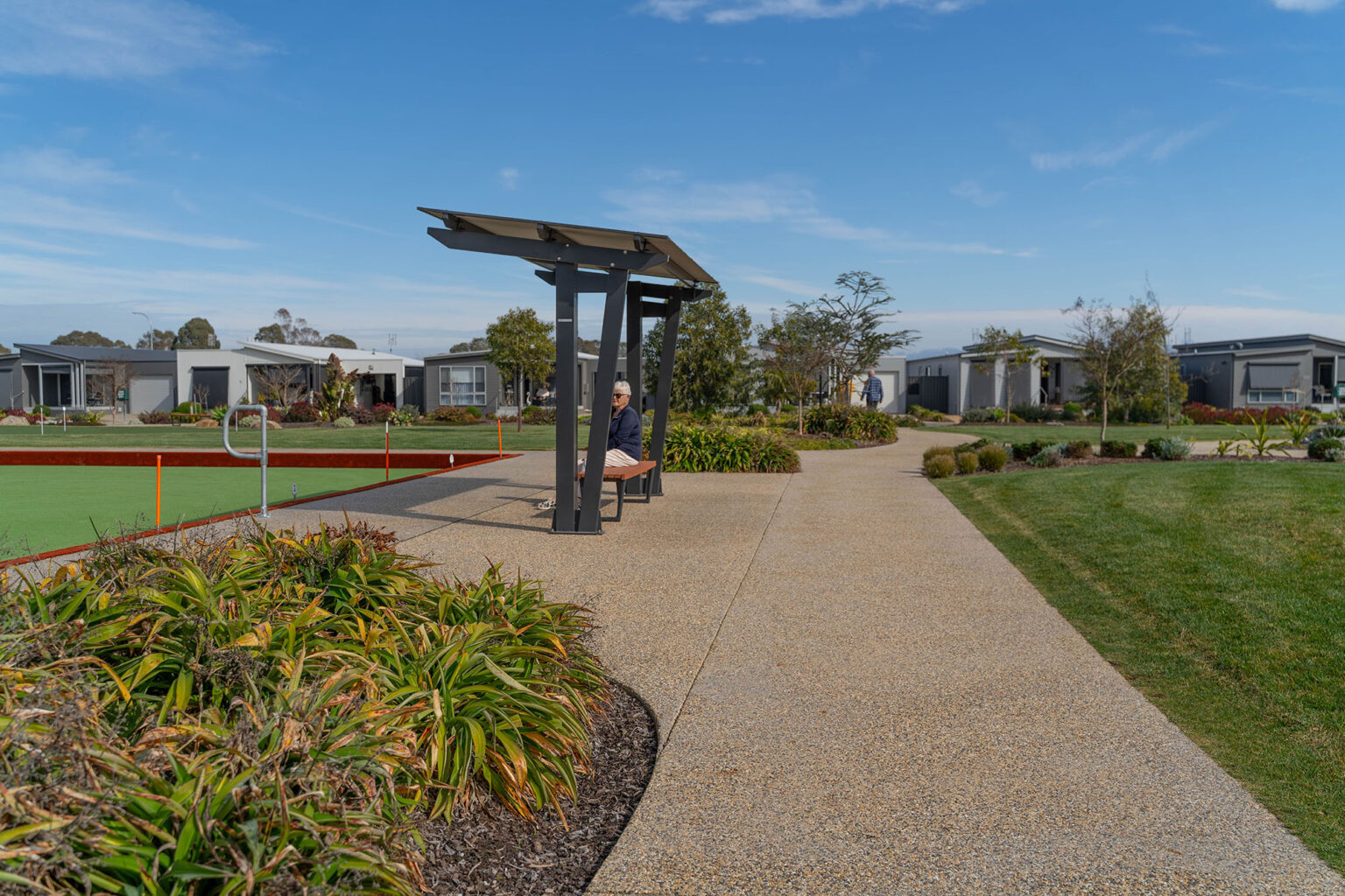 Resident facilities at the Waterways Lifestyle Village including bowling green and adjacent seating.