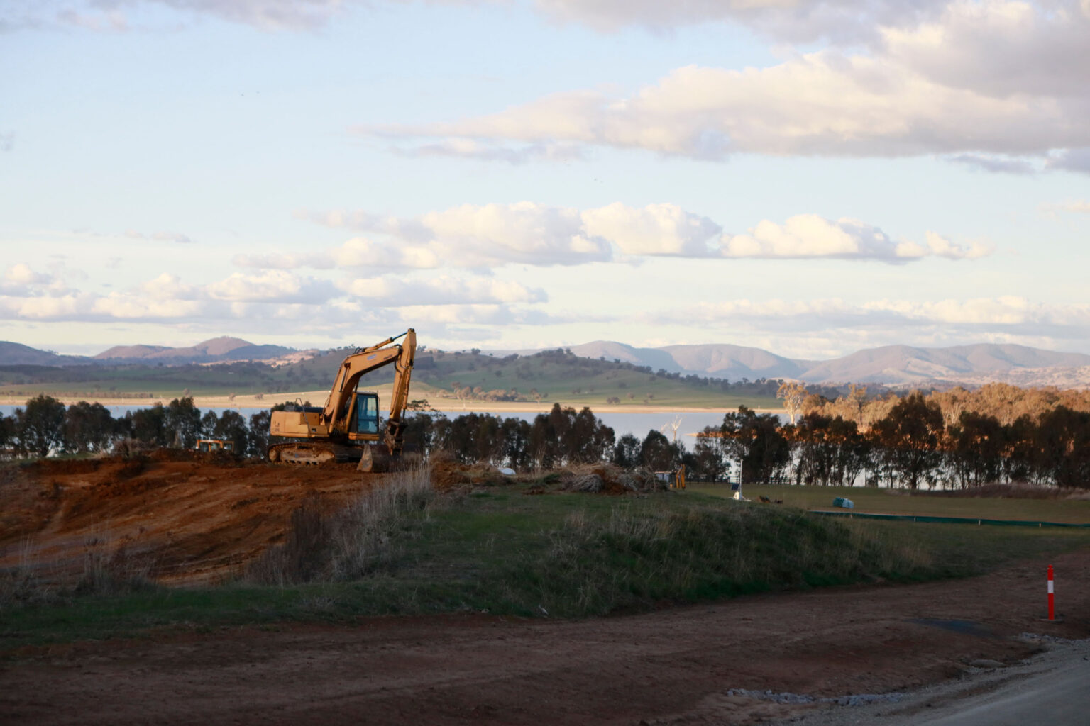 Civil construction machinery with lake in background.